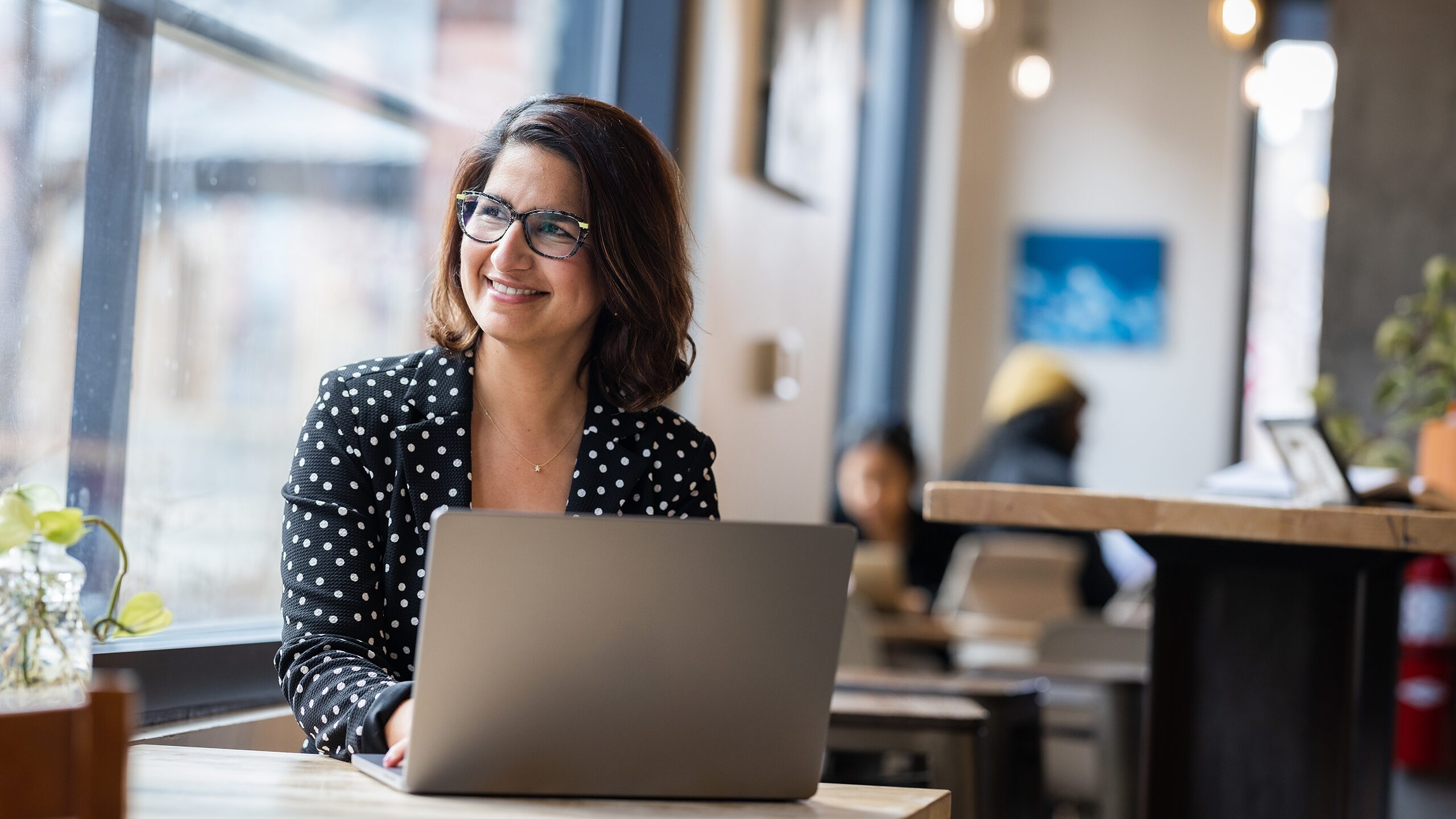 Woman working on laptop in a shared workspace.